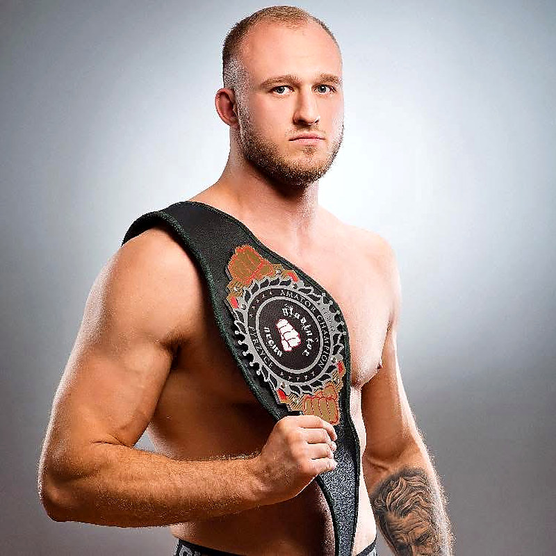 Trener MMA Kacper Olszewski z pasem mistrzowskim Gladiator Arena